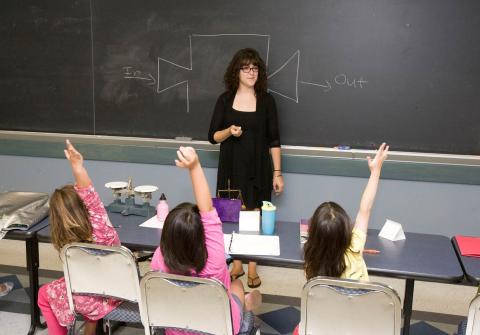 Elementary students eagerly participating in math activities.